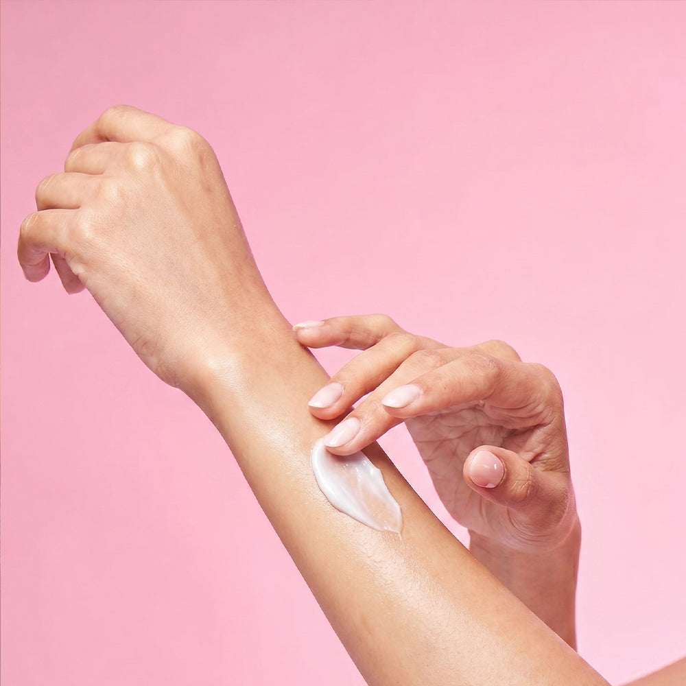 a woman applying body lotion