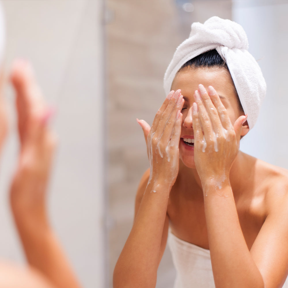 A woman washing her face over the wash basin