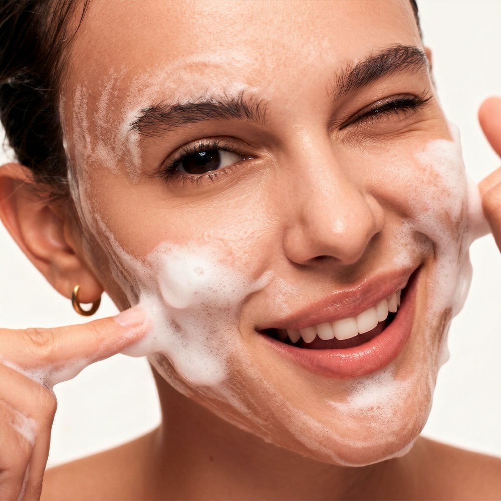 A indian women washing her face with a face wash