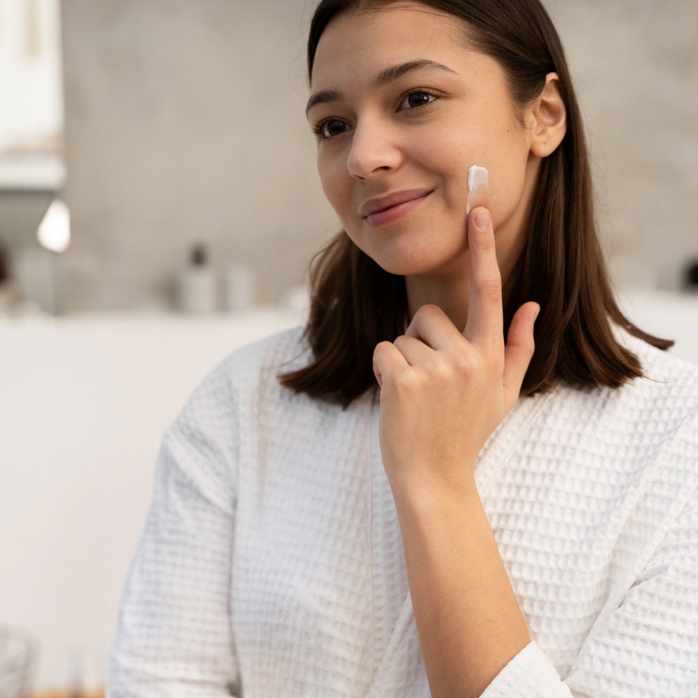 a young woman using moisturiser